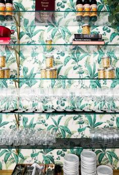
                    
                        Palm tree printed wallpaper behind a bar
                    
                