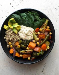 ROASTED NOURISH BOWL Ingredients olive or coconut oil, 1 - 2 tablespoons 1 large sweet potato, cut into 3/4" cubes 2 large carrots, sliced 1 1/2 cups brussles sprouts, 1 1/2 cups broccoli florets 1/2 large red onion, sliced 6 serrano chilis, 1 1/2 cups cooked chickpeas or 1 can (15oz) 1 - 2 lemons, cut into six pieces To serve 1 1/2 cups cooked quinoa 5 oz. spinach 1 - 2 avocados big dollop of hummus red pepper flakes, to garnish