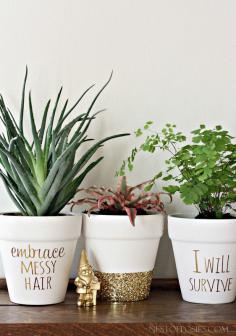 DIY Gold Foil Lettering on Flower Pots - Buy pots from the dollar store. Paint with whit acrylic paint. Wrap painters' tape around middle of pot. Brush Mod Podge on bottom. Sprinkle glitter. When fully dry (24 hours), brush more Mod Podge over glitter to set. Let dry. Gold letters done with printable gold paper.