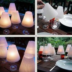 Made out of fragile parchment, each set contains 3 different shades with cute and whimsical designs that are printed in a faint white. All you need to do is take them out of the package roll them up, drop a candle into a wine glass and add the lampshade. That’s it. Instantly the white pattern is transformed to a darker shade (as if it were a shadow) and a wine glass is turned into a sweet miniature lamp.
Save-on-Crafts has a great instructions on how to make your very own Wine Glass Candle Lamp
Materials
8-1/2″ x 11″ (21.8cm x 28cm) sheets of vellum (one per lamp)
Scissors
Scissors with decorative blades
Decorative paper punch in desired shape
Glue pen
Wineglass
Votive candle or a LED Battery Operated Tea Light
Candle putty (floral clay)
1.Lampshade Pattern (PDF file click here)
To view this file, you will need Adobe Acrobat Reader
2. Trace the lampshade pattern onto the sheet of vellum. Cut the straight ends and the inner curve using plain scissors with decorative blades.
2. Punch designs about 1″ (2.5 cm) from the lower edge, spacing the designs evenly.
3. Apply a thin line of glue (a glue pen works well for this) to one straight end. Lap the other end over the glued end, forming the shade.
4. Secure the votive candle and set the lampshade atop a wine glass