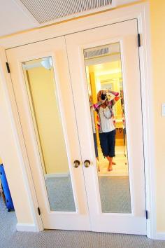 what a great idea! add cheap framed mirrors to closet doors, painted frame to match. Looks like built in.  Guest bedroom